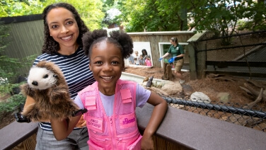 Girl with river otter puppet at ZooAmerica